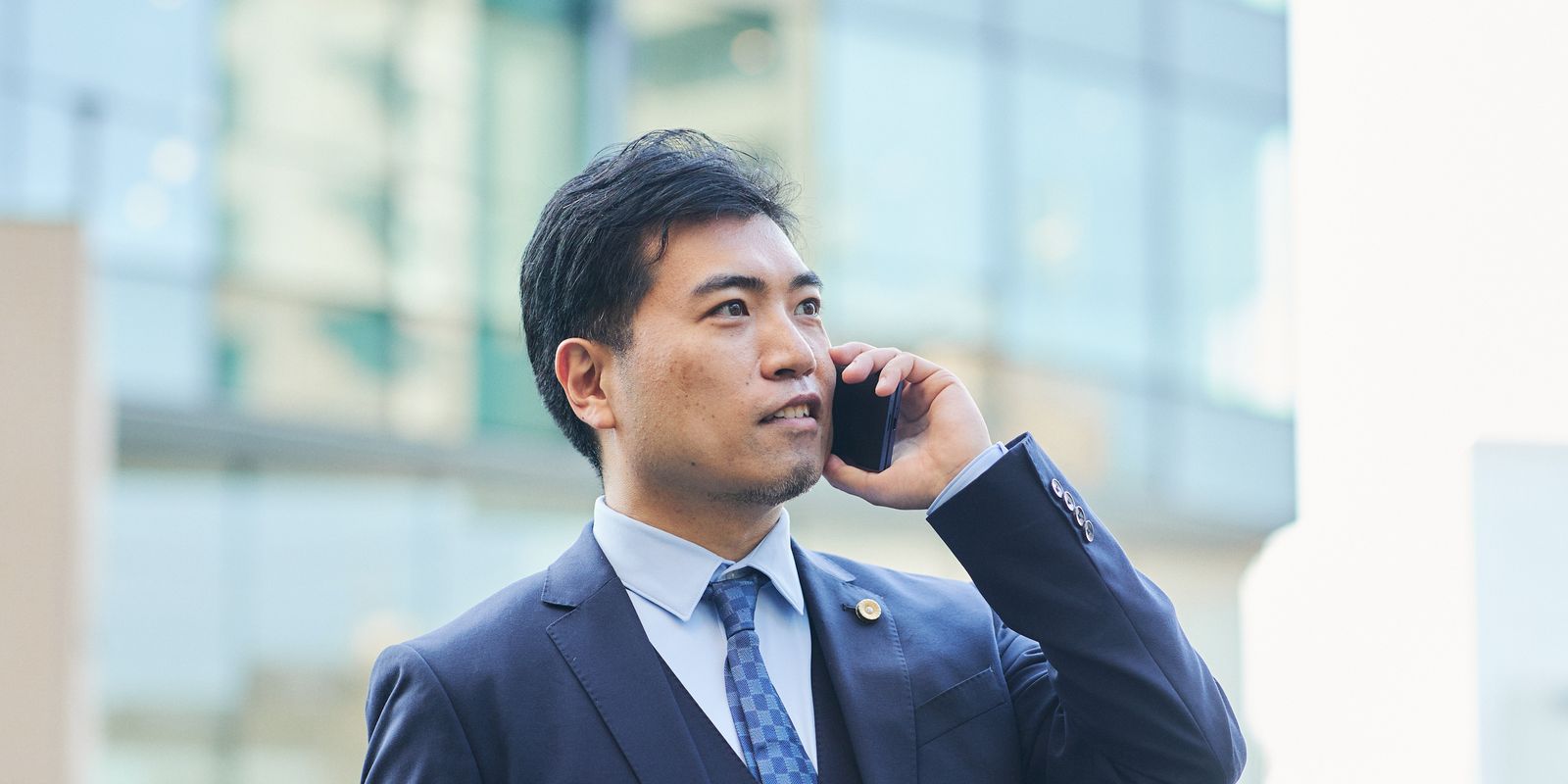 街なかで電話に応じる弁護士 福田 匡剛