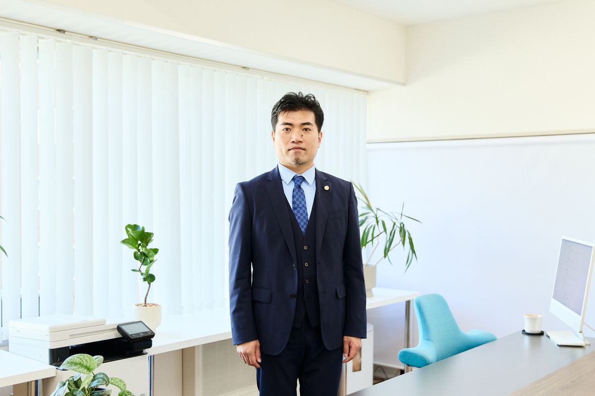 事務所の室内に立つ弁護士 福田 匡剛